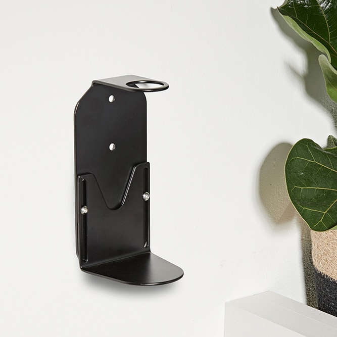 A black wall mounted soap dispenser holder installed on wall